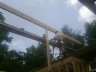 Carpenter setting a ridge beam over a new addition frame — Ice Dam Removal by Roofing Brothers in Dyersville