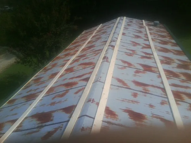 Rusted metal roof panels with new wood purlins before replacement — Storm Damage Roof Repair in Dyersville by Roofing Brothers