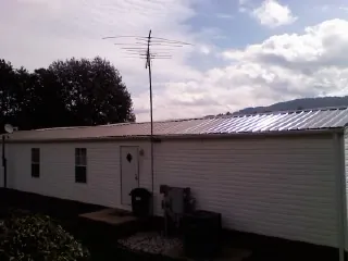 New metal roof on a single wide mobile home with a TV antenna in Dyersville