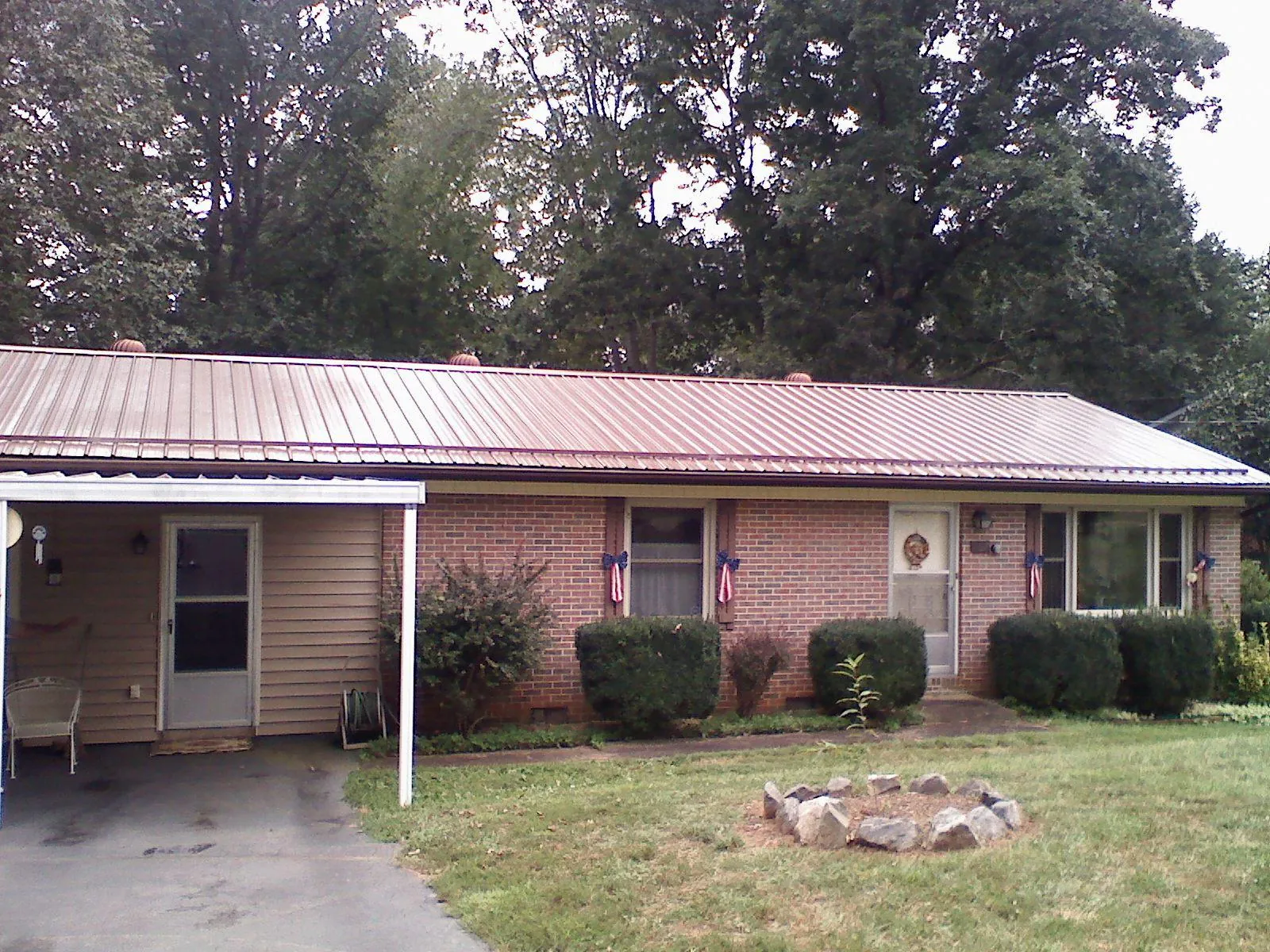 Bronze metal roof and carport on a brick ranch home — Roof Repair work by our crew in Dyersville